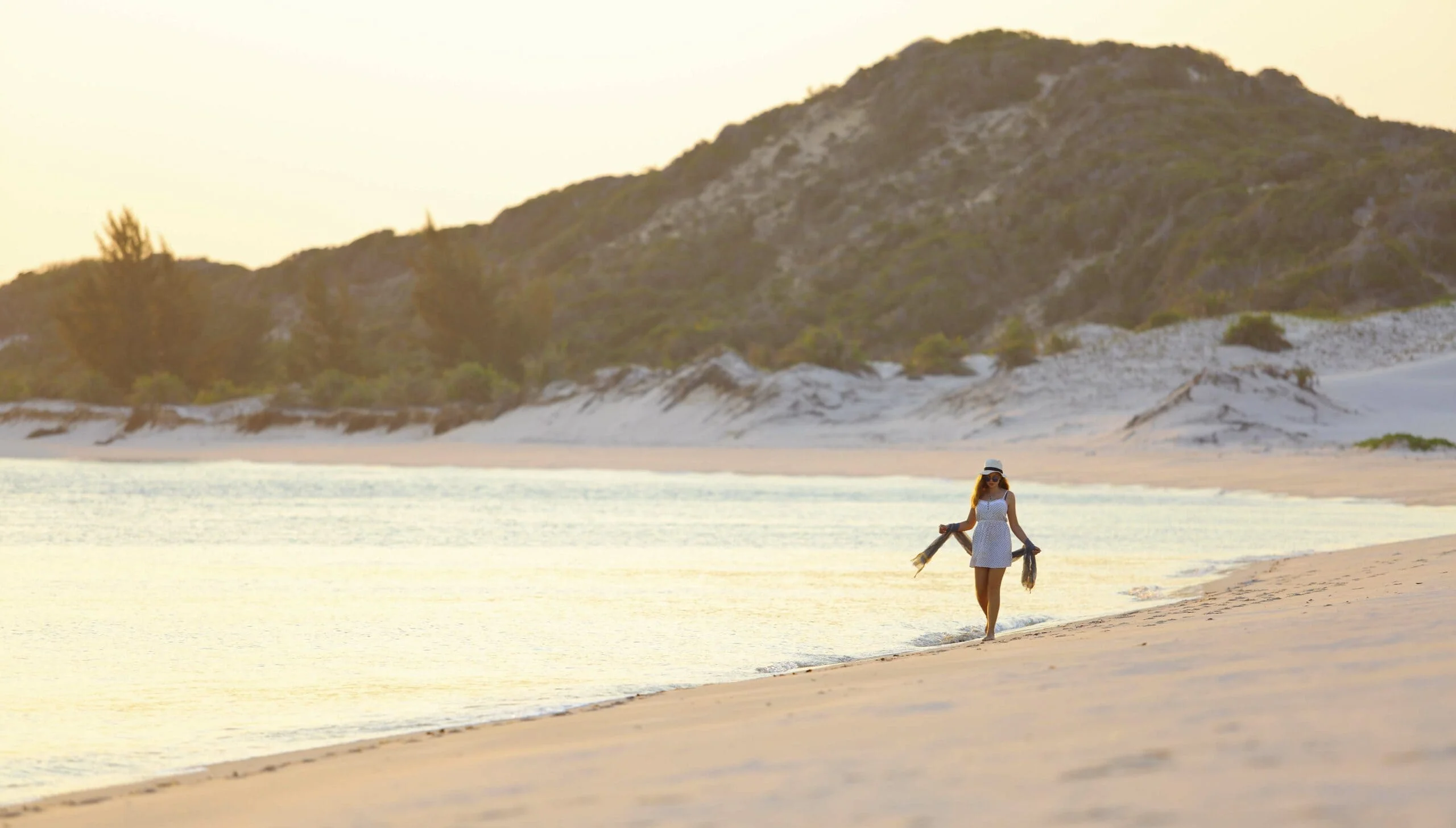 Woman's walking along a beach at Azura Benguerra Island, Mozambique